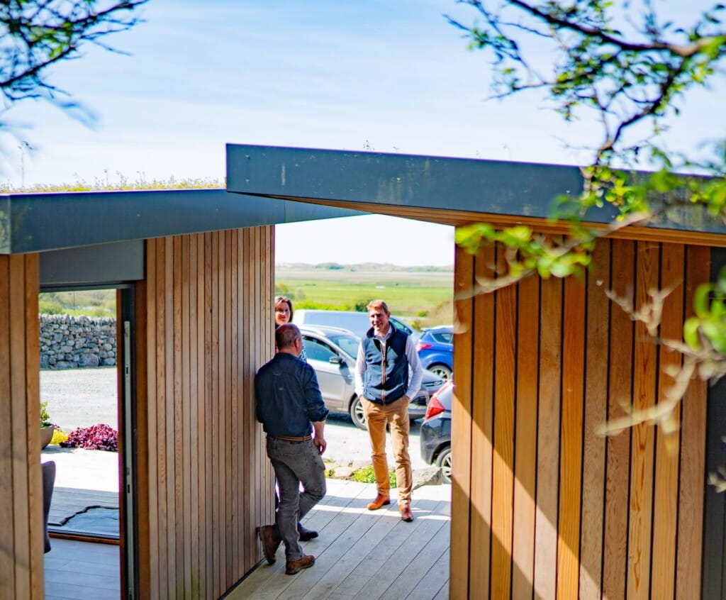The Baileys team chat outside a modern property